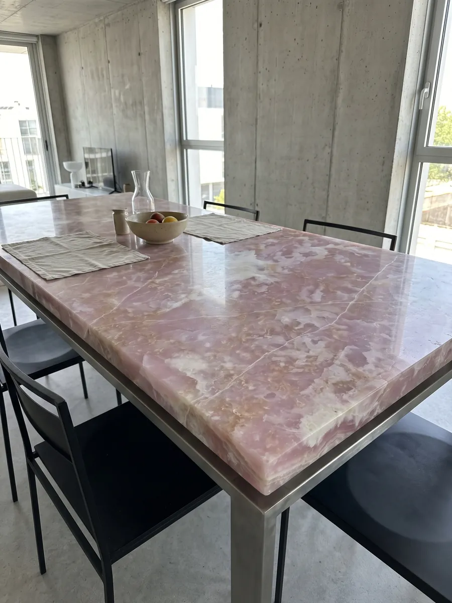 Dining table with a pink onyx top on a steel base: lilac pink with white clouds and fine white lines running across it