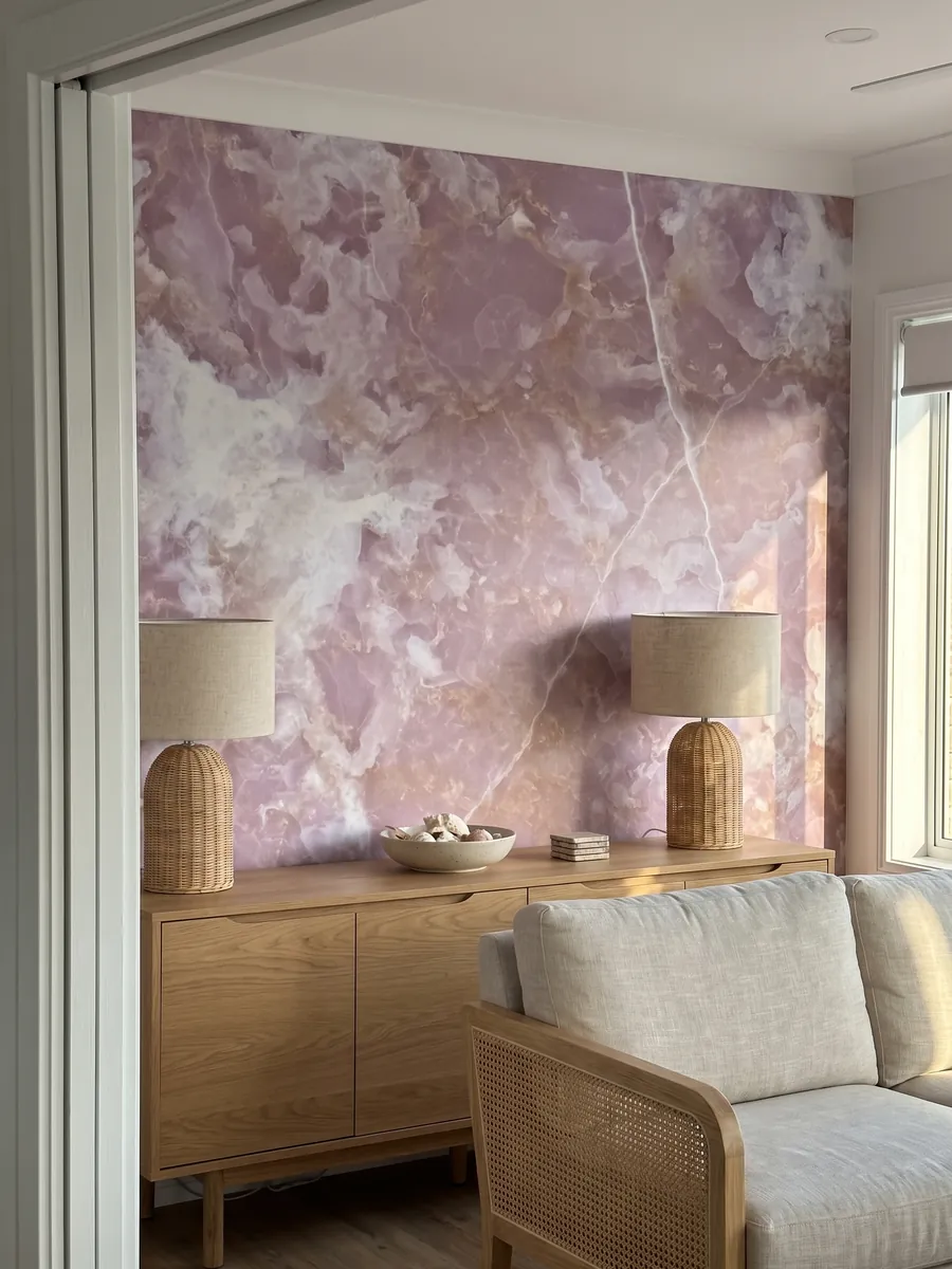 Accent wall clad in pink onyx above a low wooden cabinet: lilac pink with white clouds and fine white lines running across it