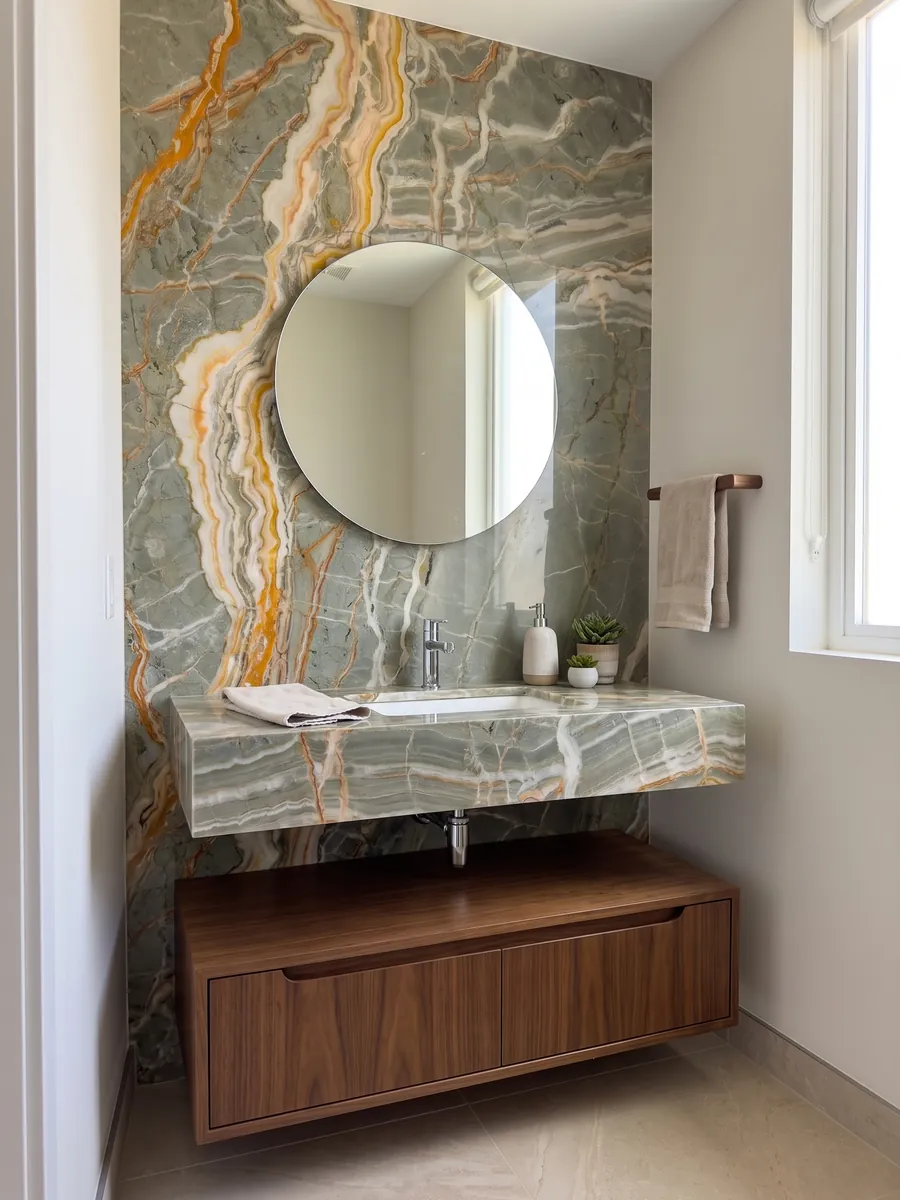 Guest bathroom with a Rainbow onyx wall and floating vanity top with a round mirror: gray-green crossed by branching orange and yellow veins