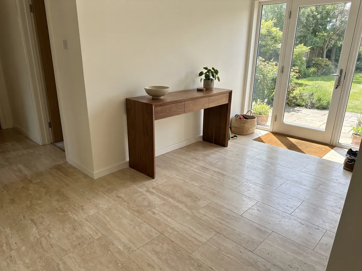 Entryway floor in large beige Navona travertine slabs in natural light: light beige with faint horizontal bands