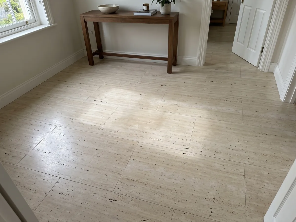 Entryway floor in large light beige Roman travertine tiles with natural light: light cream with fine horizontal lines and small aligned pores