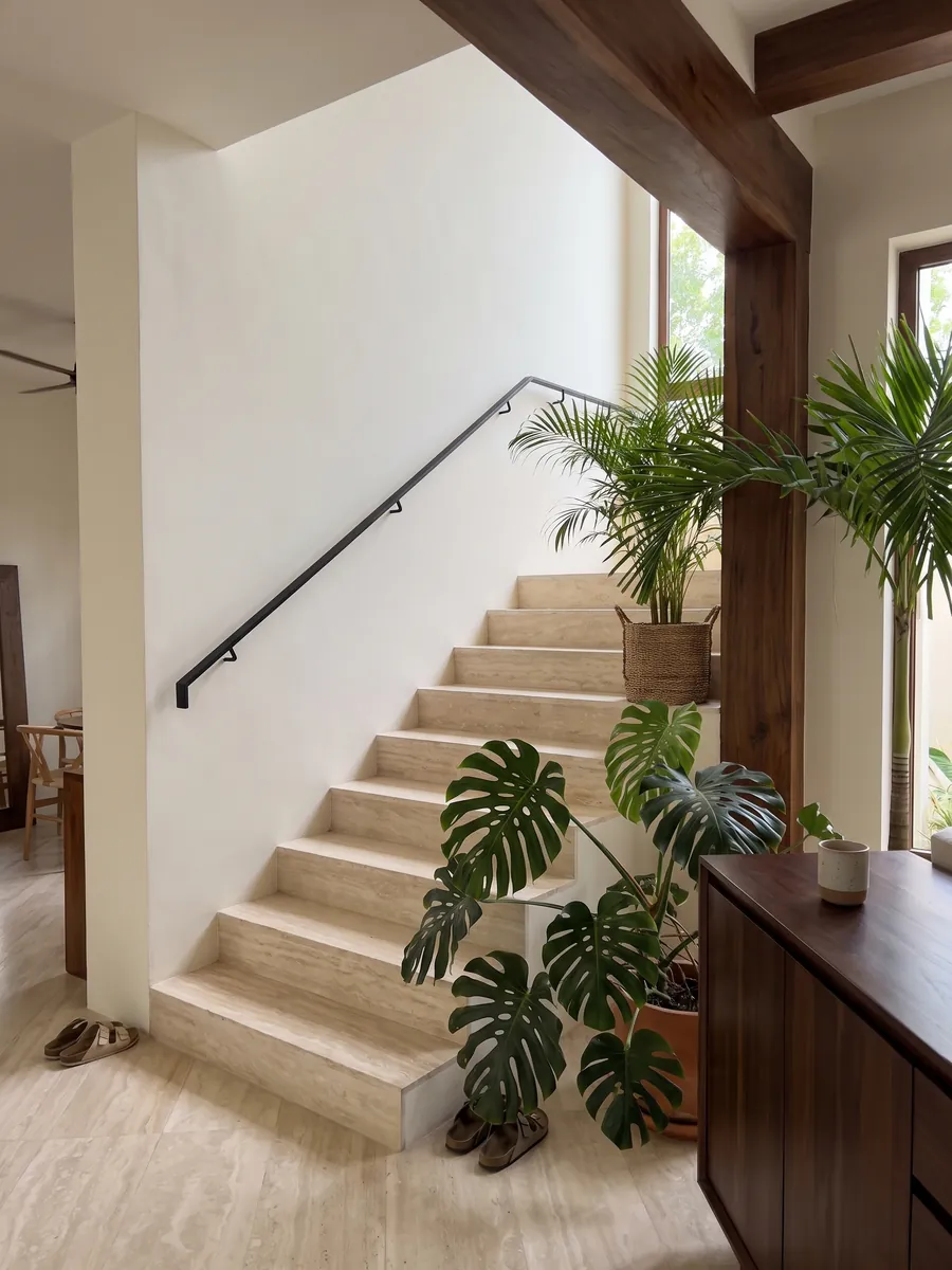 Indoor staircase with White Travertine steps and a handrail: very uniform ivory cream, with soft waves barely visible