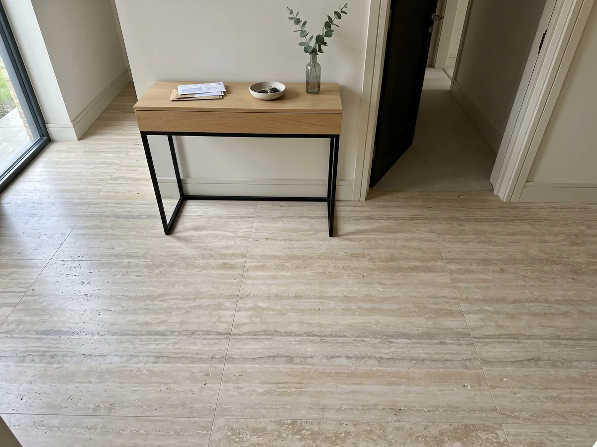 Entryway floor in large gray Ocean Silver travertine slabs with natural light: fine beige and gray horizontal stripes with some pores