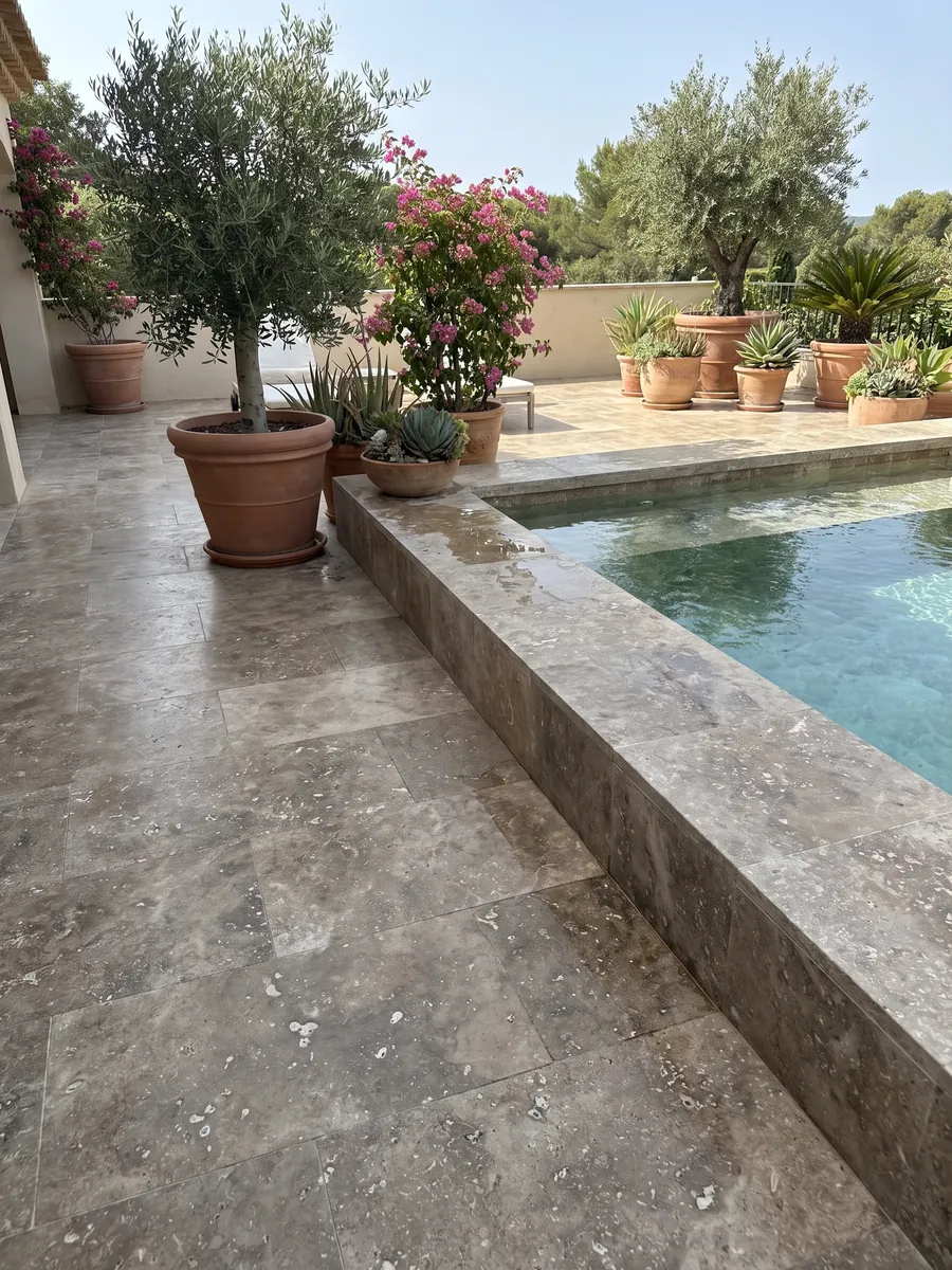 Terrace floor and pool coping in brown Noce travertine with planters: grayish brown with irregular light blotches and visible pores