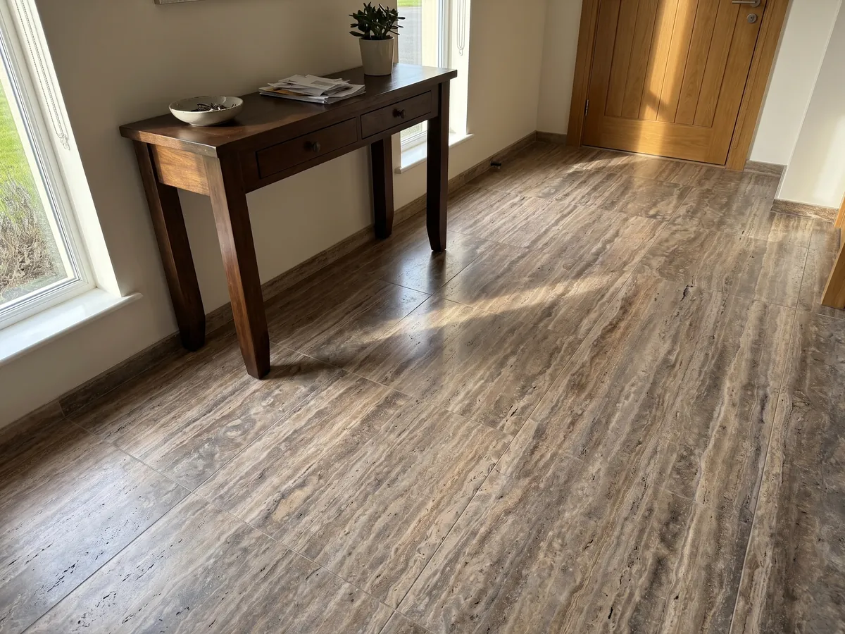 Entryway floor in large brown Pantheon travertine slabs with natural light: brown with fine, parallel, lighter horizontal bands