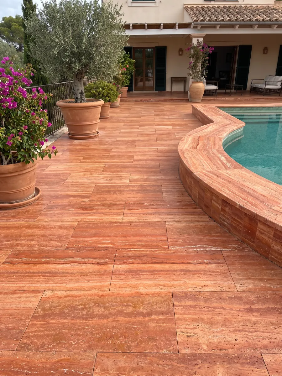 Terrace floor and pool coping in red travertine with planters: intense orange-red in horizontal bands with fine cream lines