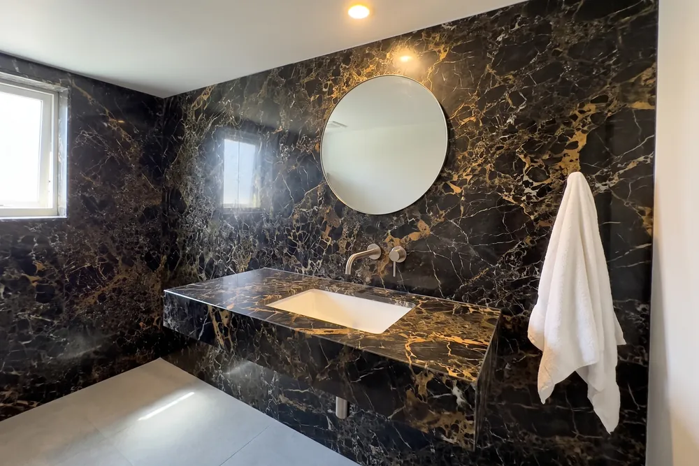 Bathroom with a floating Portoro marble vanity and wall