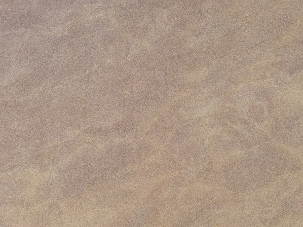 Santafiora Venata sandstone detail: soft light and pinkish waves over the matte sandy beige