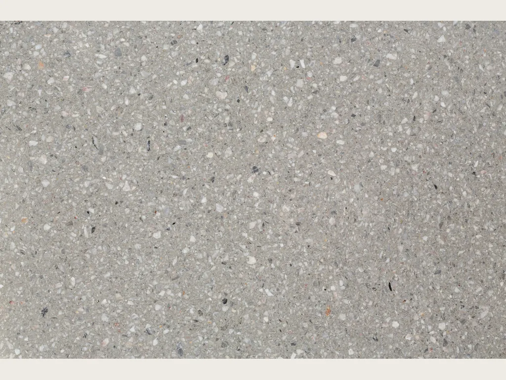 Slab of Fior di Pesco Grey engineered marble with resin: light gray background with small white fragments and dark dots