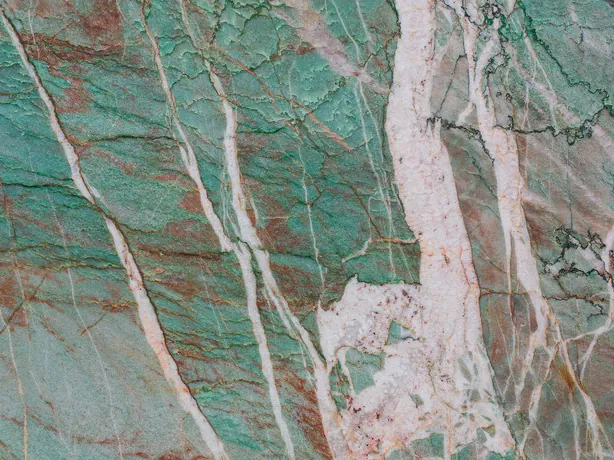 Detail of green Amazzonite Cristallo quartzite: fine rust-red and dark lines on the glossy polish