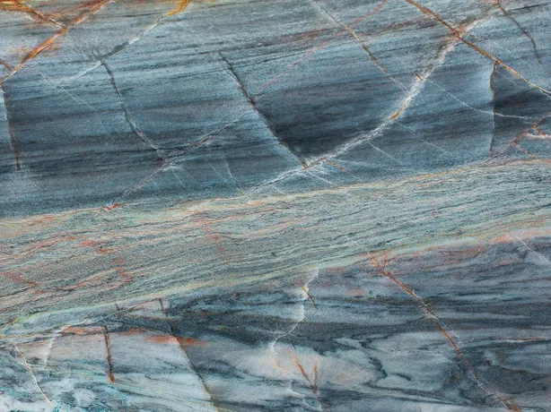 Close-up of Blue Atlantic quartzite: ocher-orange lines and white veins crossing at an angle over the high-gloss polish