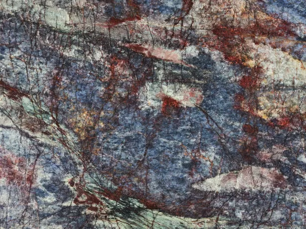 Blue Luise quartzite detail: rust red, cream and green veins over the glossy polish