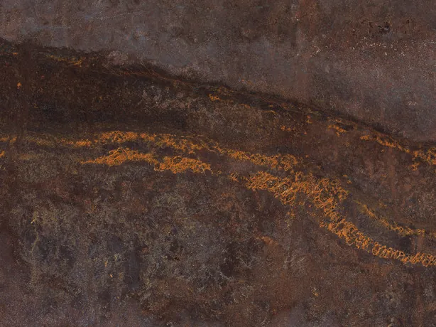 Close-up of brown Bronzite quartzite: golden orange strokes and dots over the darkest band of the chocolate brown