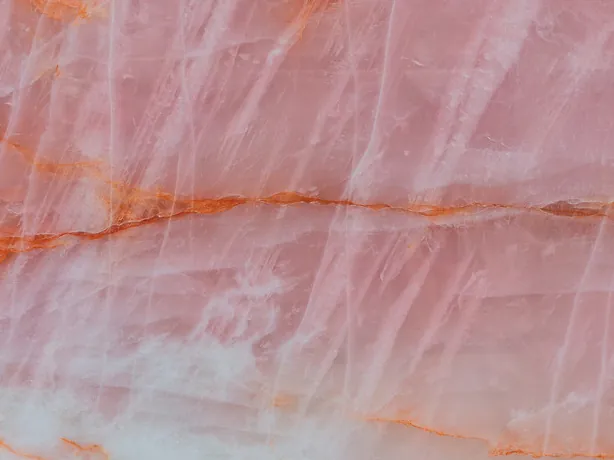 Detail of Cristallo Rosa quartzite: reddish orange veins and white strokes over the salmon-pink background