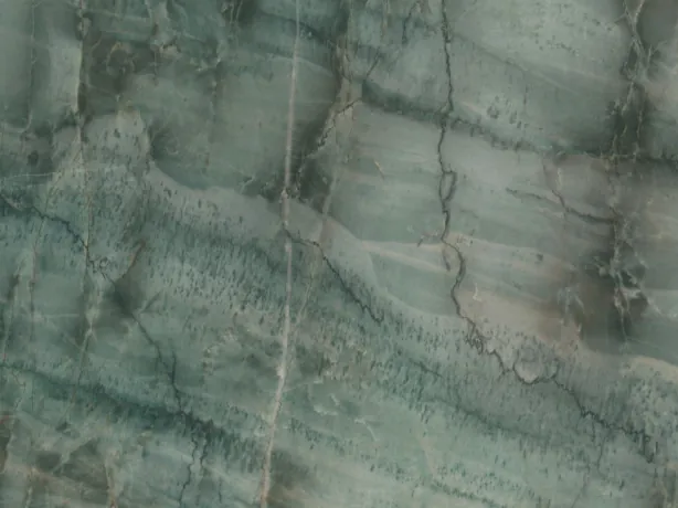 Close-up of Da Vinci quartzite: dark green veins crossing light bands over the shine of the polish