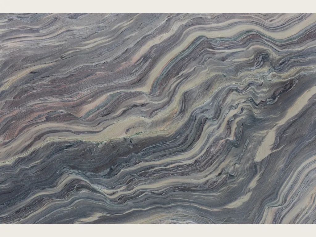 Slab of Explosion Blue quartzite: dense blue grey and cream waves on the diagonal over a violet background