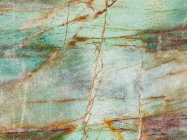 Detail of Green Luise quartzite: rust red and ochre veins over turquoise and white areas, polished finish