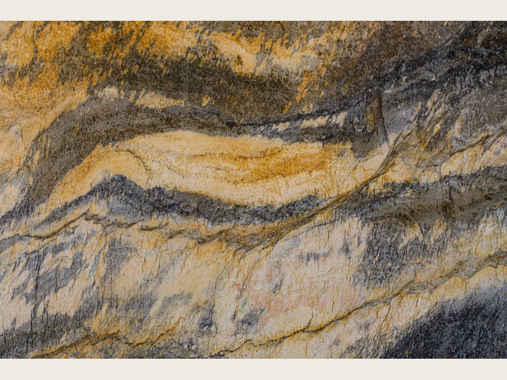 Jacaranda quartzite slab: wavy horizontal bands of mustard, cream and dark gray over an ochre background
