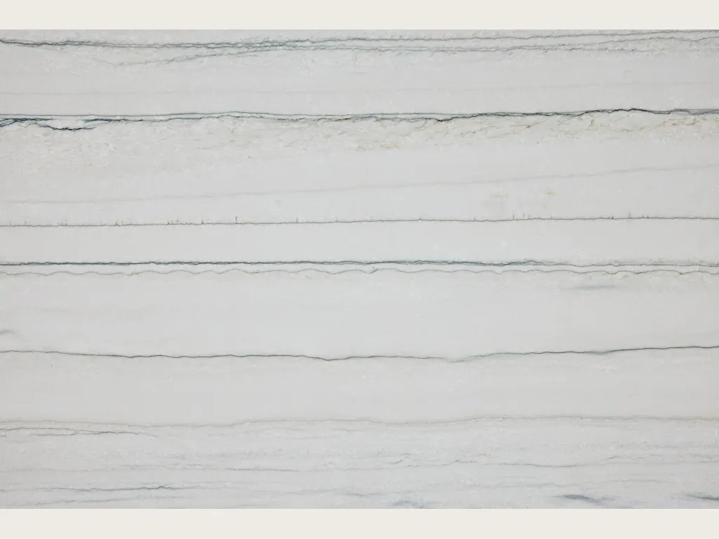 Slab of White Macaubas quartzite: a bluish white background with fine, almost horizontal dark grey lines (another slab)