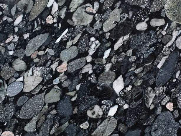 Close-up of Marinace Black: tightly packed pebbles of many sizes over the black background