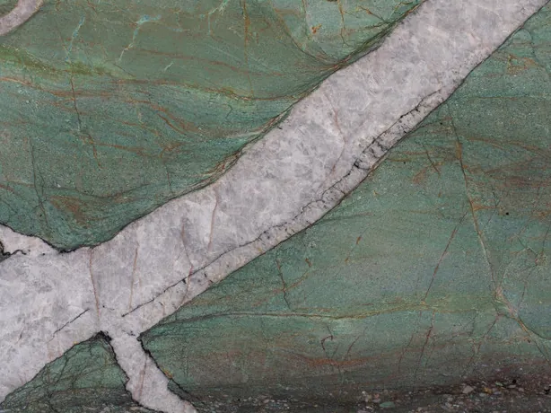 Close-up of green Patagonia Green quartzite: lilac gray veins and brown lines over the polished jade green