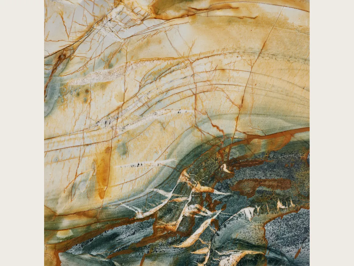 Slab of beige Polaris Gold quartzite: golden cream background with a net of brownish orange veins and a petrol gray zone