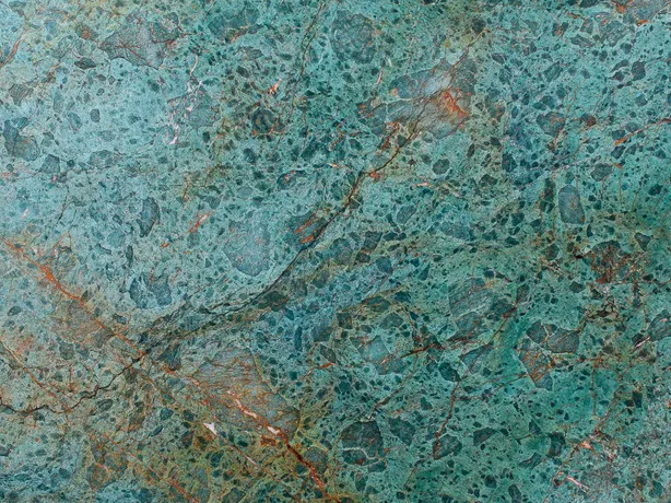 Close-up of green Tanzanite quartzite: turquoise grains and the rust red band over the blue-green background