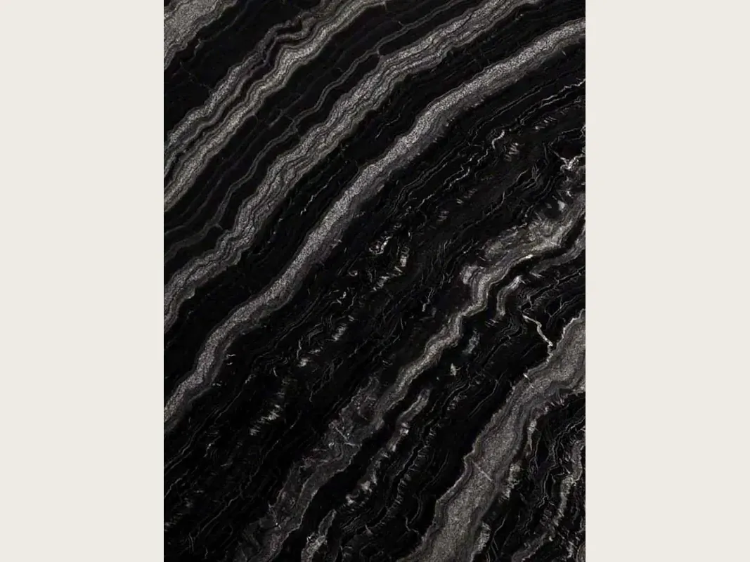 Slab of black Agata Black granite: black with diagonal wavy silver gray bands, polished to a gloss