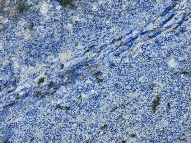 Close-up of the deep blue grain of Azul Bahia with the sheen of the polish