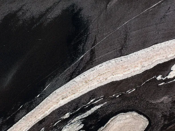 Detail of the black Copacabana granite slab: the shine of the polish and the contrast of the cream band over the black