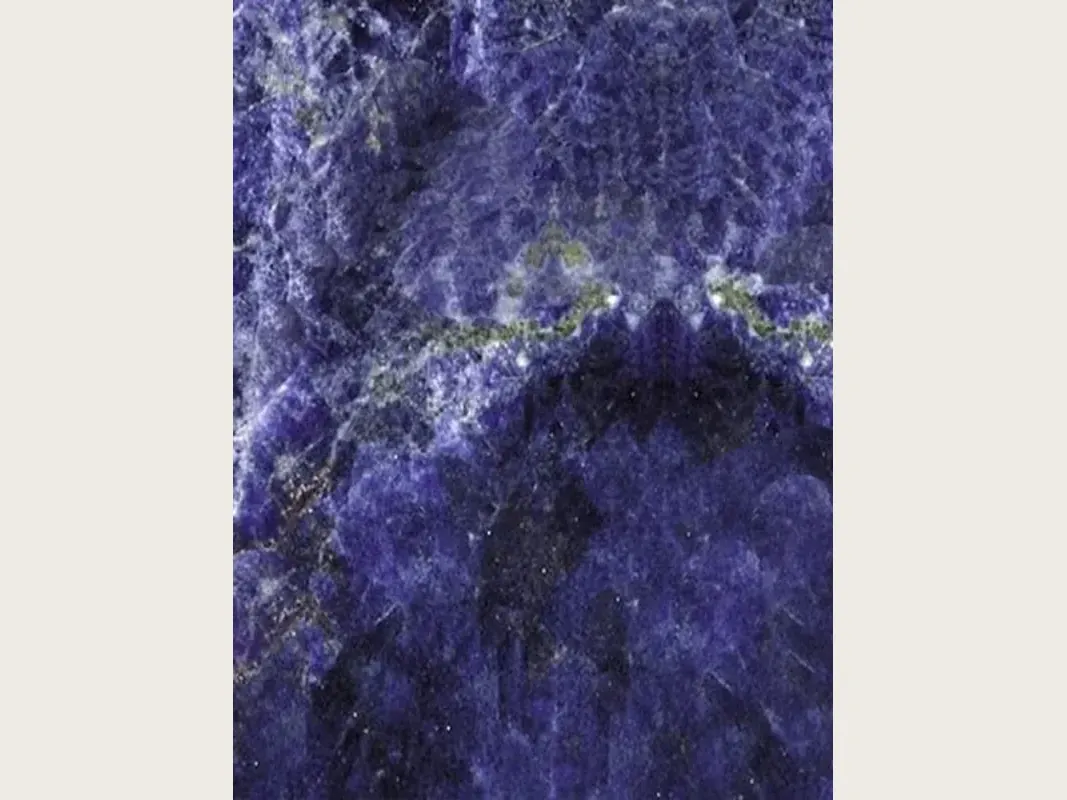 Jeriba Blue granite slab: intense violet blue with white clouds and a horizontal golden green line