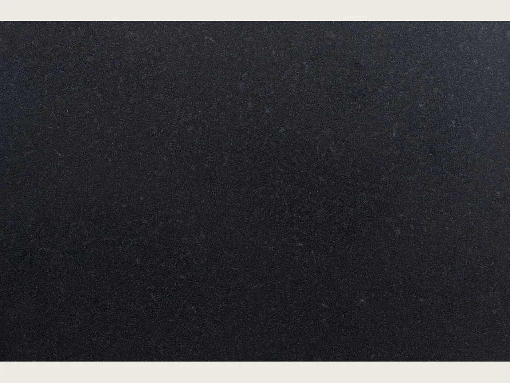 Slab of Nero Assoluto black granite: a deep, uniform black, no veins, polished to a mirror gloss