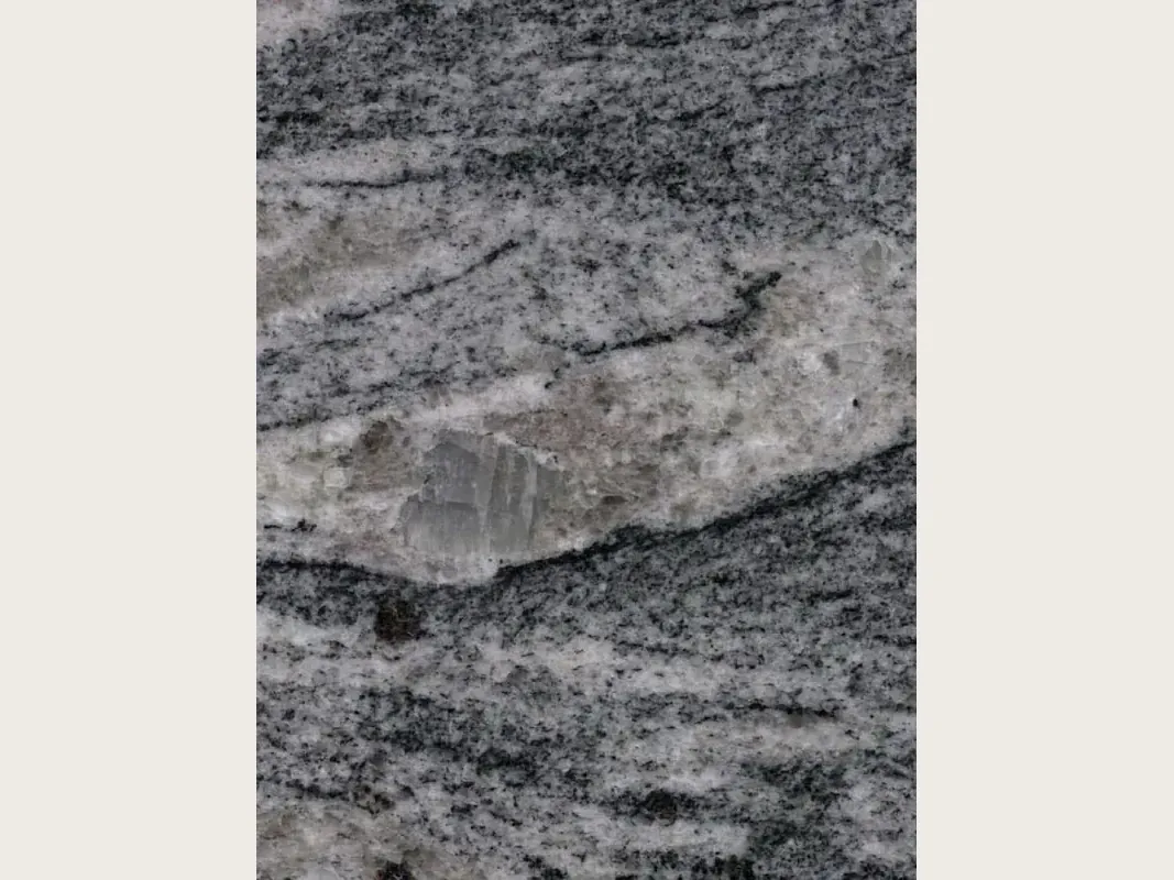 Slab of Piracema White gray granite: horizontal wavy bands of gray and white with one large light fragment