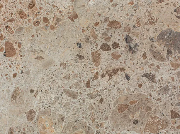 Close-up of beige Ambrosia marble: brown and rust fragments in several sizes on the beige background