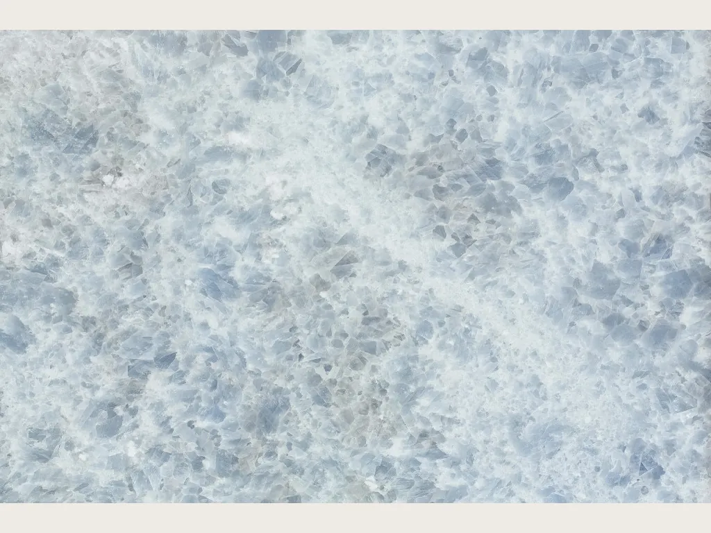 Slab of Azul Calcite Marble: gray-blue crystals on white, with a diagonal white band
