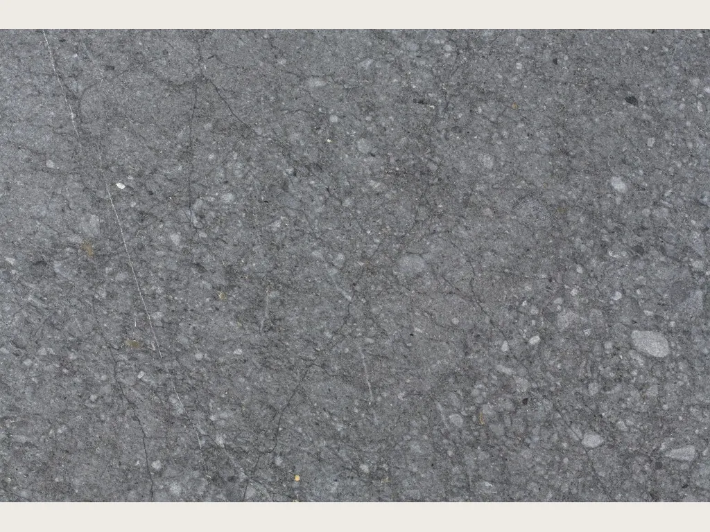 Slab of Blu Masaccio marble: uniform dark gray with scattered light gray speckles and fragments