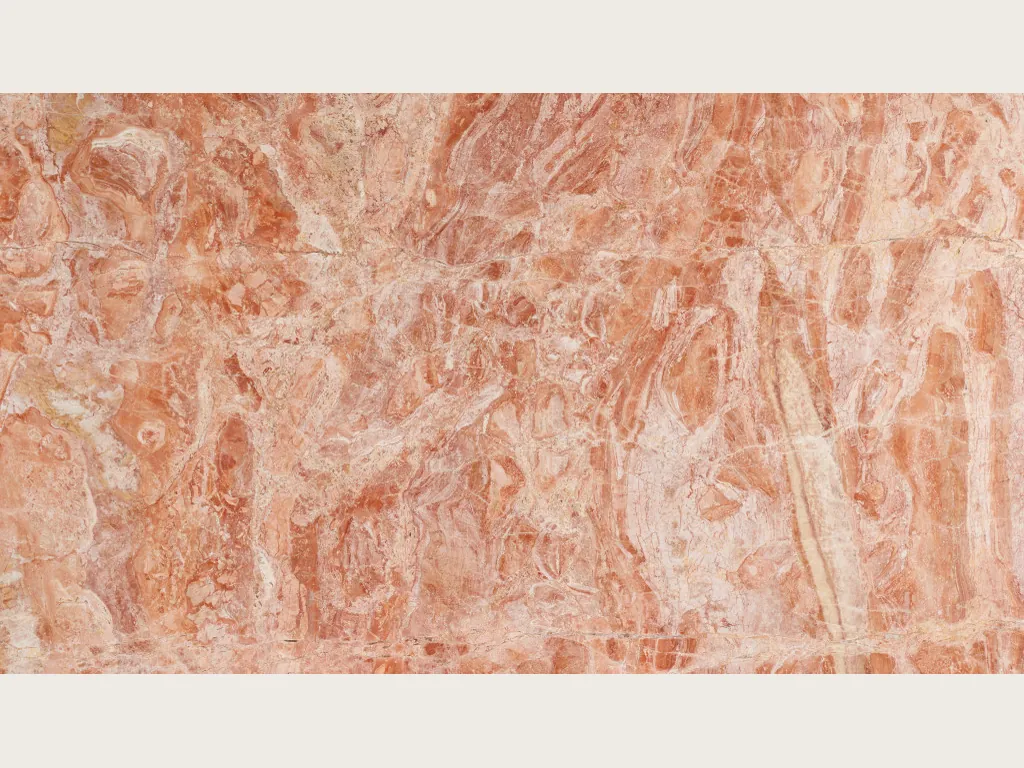 Slab of pink Breccia Bohemien marble: a dense mix of coral and light beige fragments on a salmon pink background