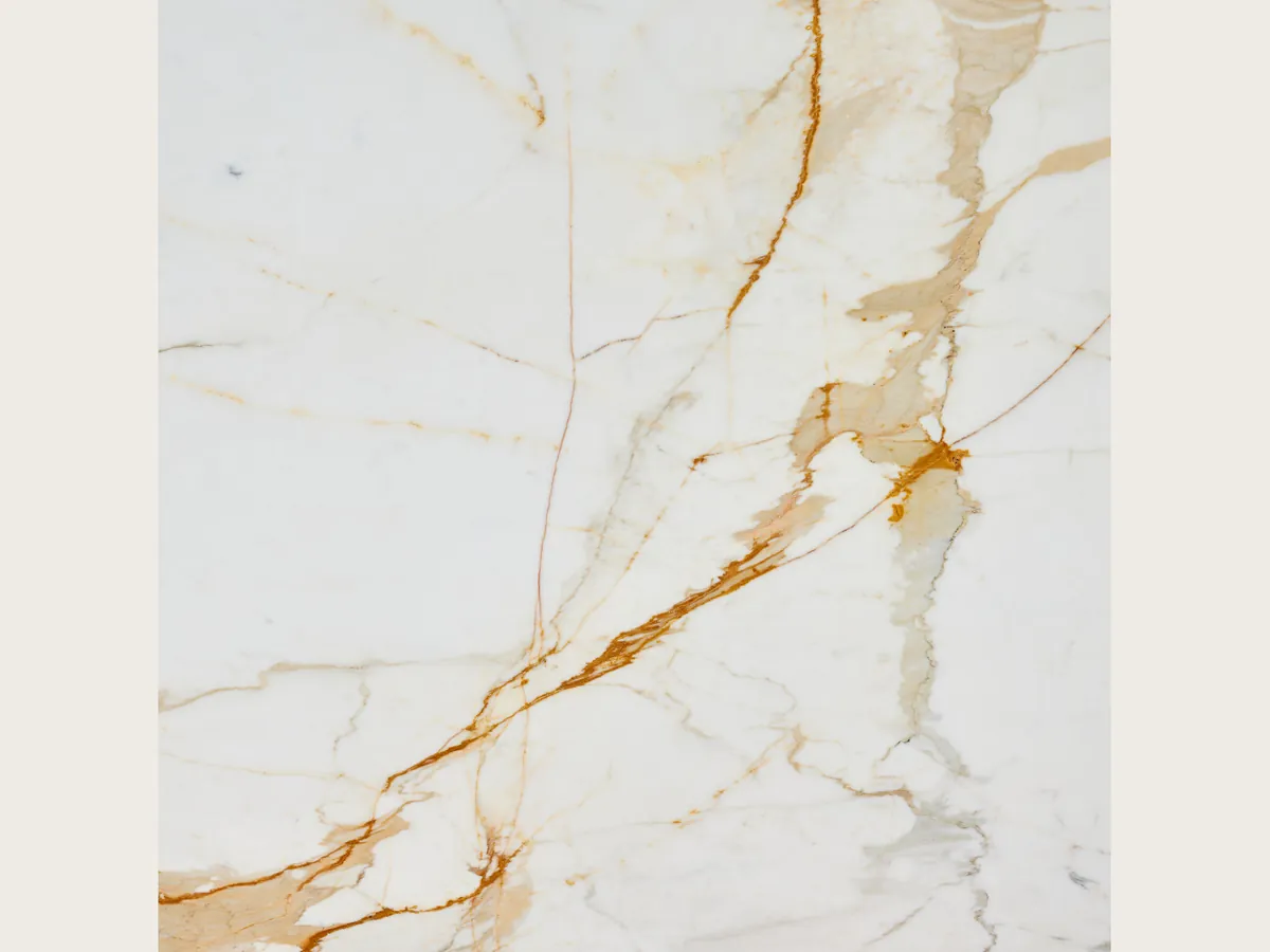 Slab of white Calacatta Oro marble: a white background with golden ochre veins running diagonally
