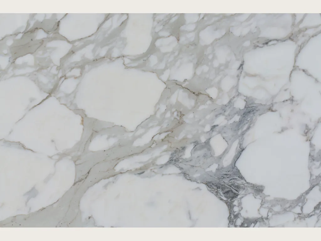 Slab of white Calacatta marble: large white fragments wrapped in wide, soft light gray veins