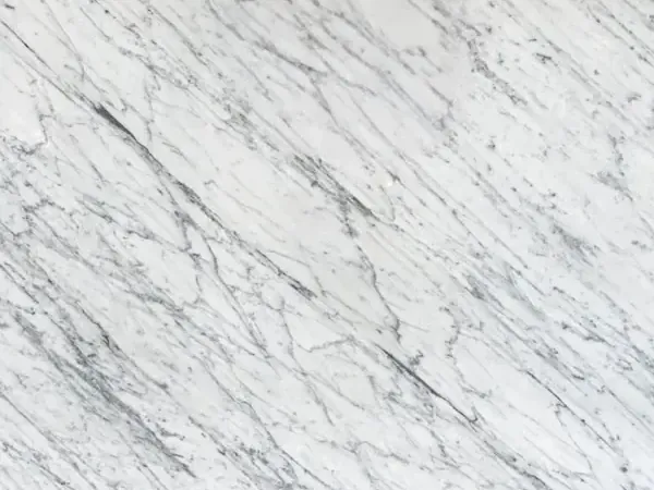 Slab of Carrara C marble: grayish white background with fine, parallel gray veins on the diagonal