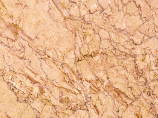 Crema Valencia marble detail: fine brown veins crossing over the salmon