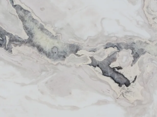 Detail of white Dover White marble: the irregular path of the dark gray vein between beige waves