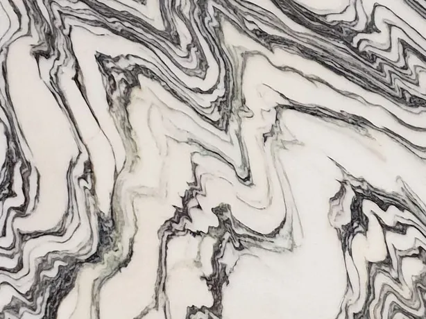 Detail of white Fantastico Arni marble: dark grays and black folded over the white