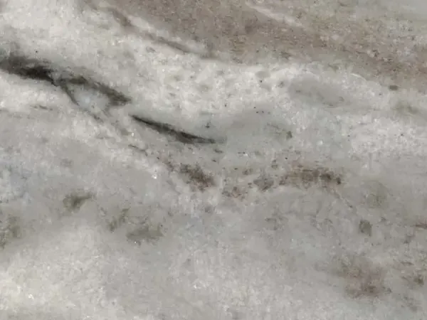 Slab of Fantasy Brown marble: light gray background, white clouds, diffuse bands in a soft diagonal and gray-brown streaks