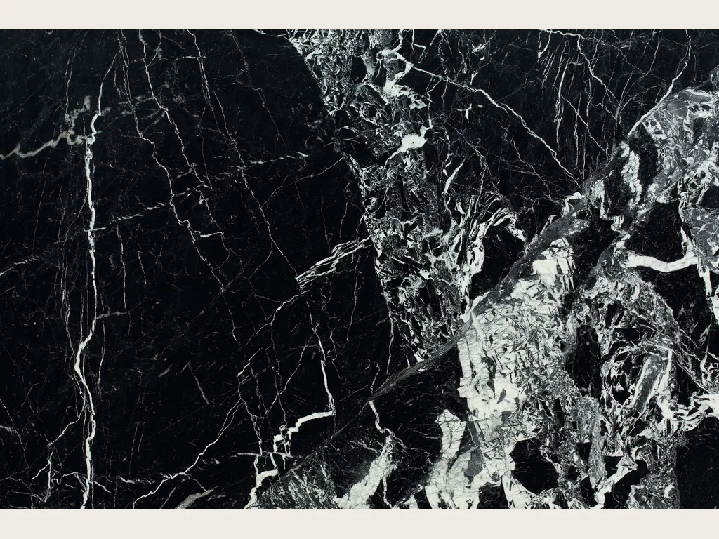 Slab of black Grand Antique marble: deep black with fine white veins and a dense area of broken white fragments