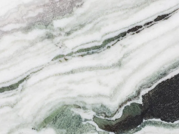 Close-up of Panda White marble: thick black bands and green touches over the white