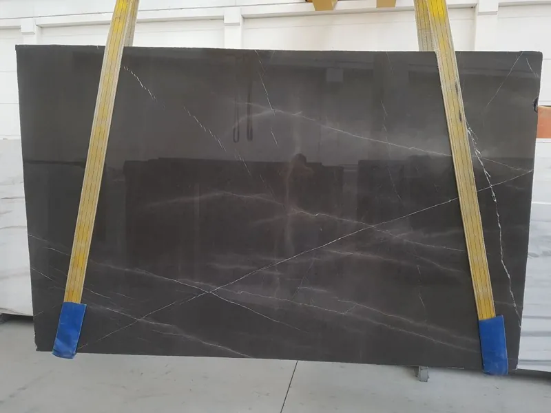 Slab of gray Pietra Grey marble: a dark gray background with fine light gray veins set on the diagonal