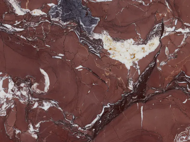 Detail of Rosso Cardinale marble: irregular white veins and gray-violet stains over the polished burgundy