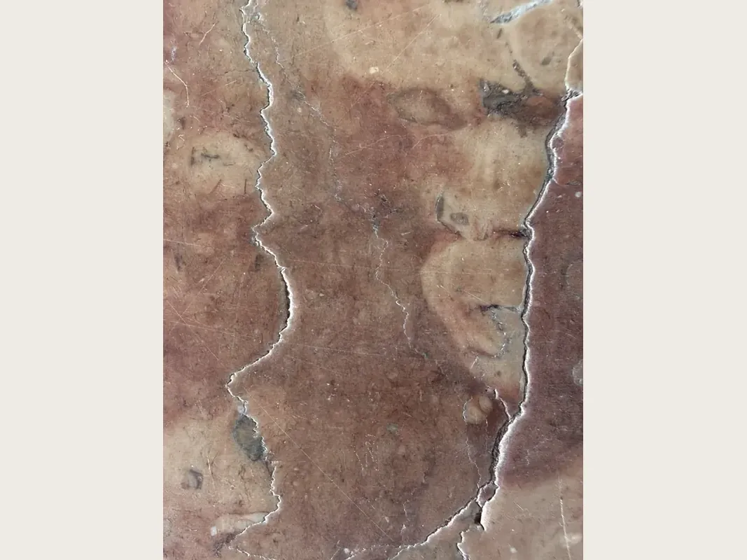 Chapa de mármore vermelho Rosso Verona: fundo vermelho arroxeado com nuvens bege e dois veios brancos verticais