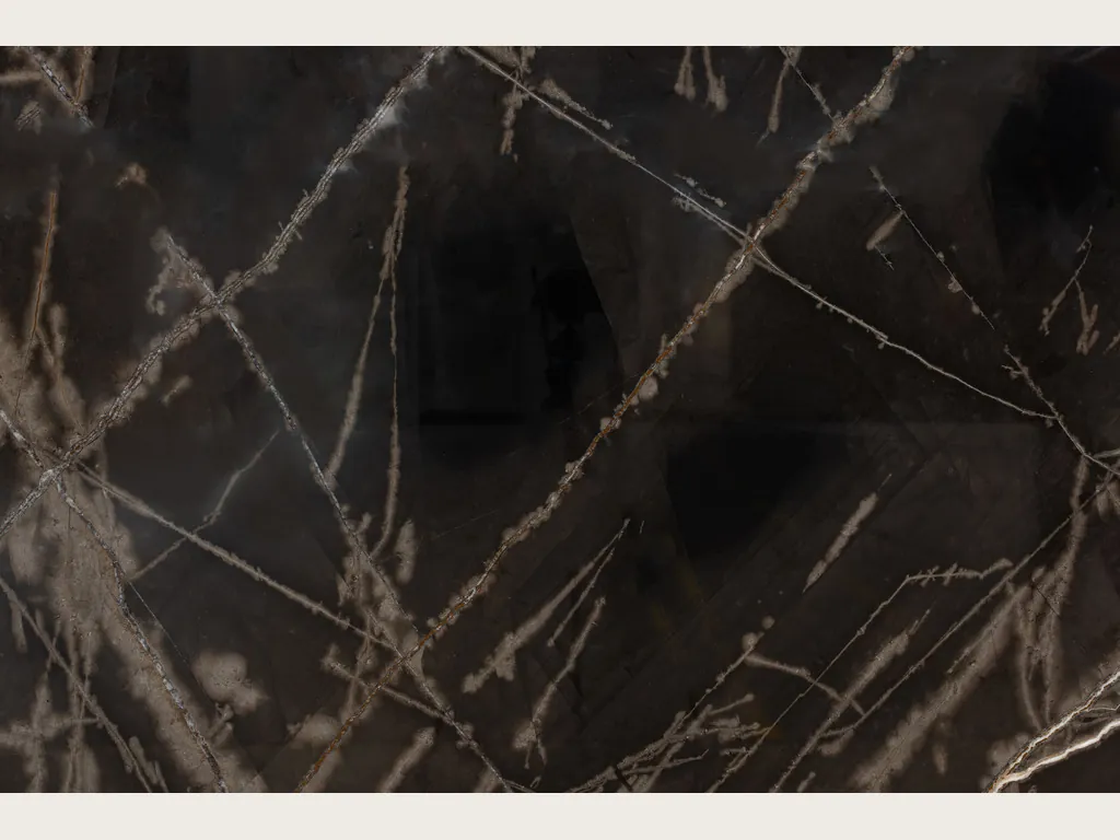 Slab of black Sahara Bronze marble: brownish black background with fine bronze strokes that cross